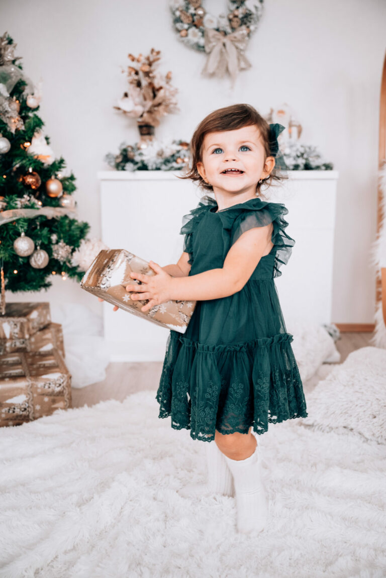 Dievčatko pózuje s darčekom vo vianočnom prostredí